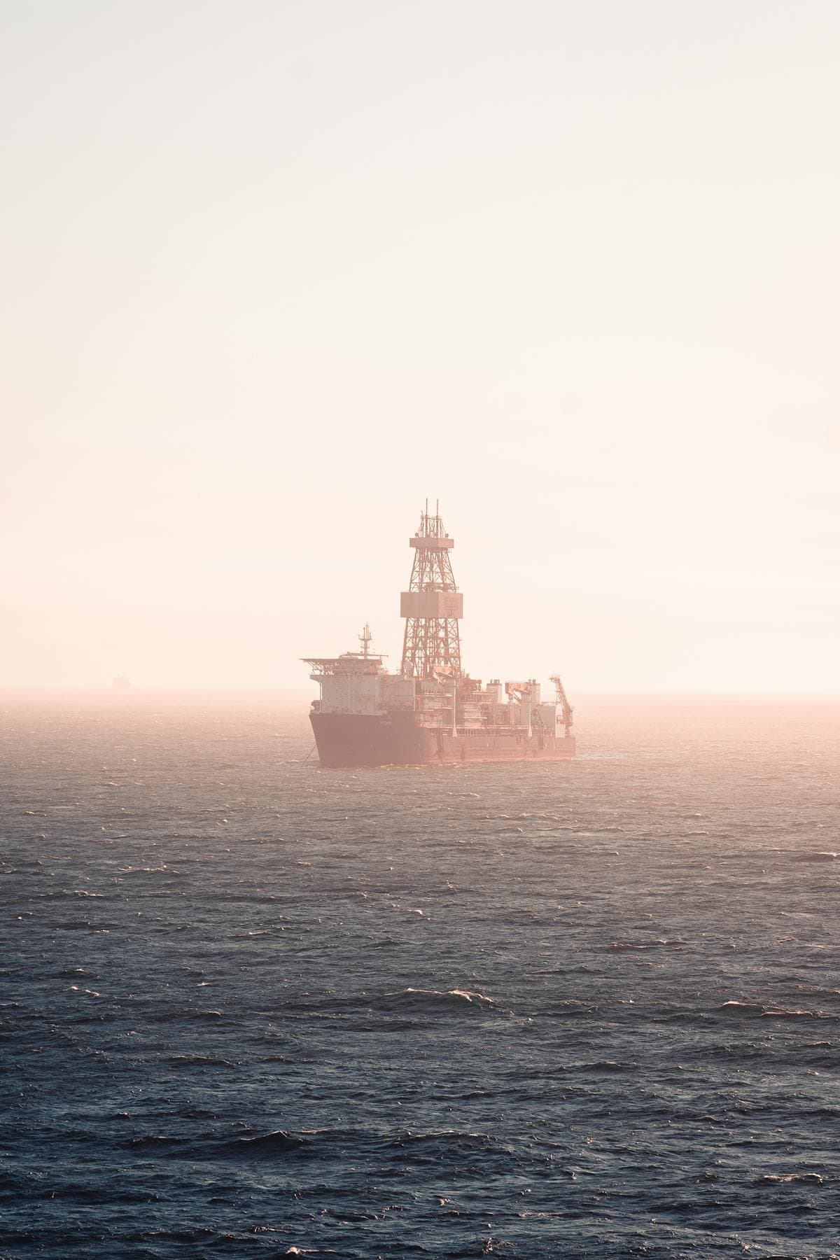 A large cargo ship silhouetted in heavy fog on a gray Atlantic sea