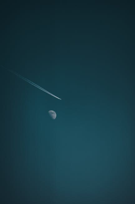 A jet contrail crossing the moon against a dark night sky, a reminder of Cooper's airborne escape