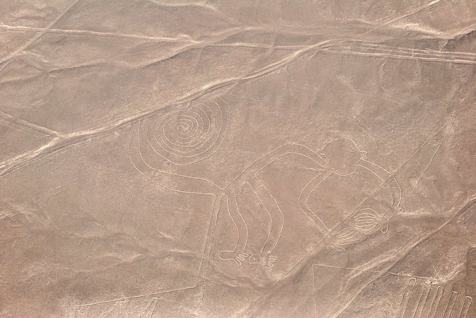 Aerial photograph showing the spiral and animal figures of the Nazca Lines stretching across the Peruvian desert floor