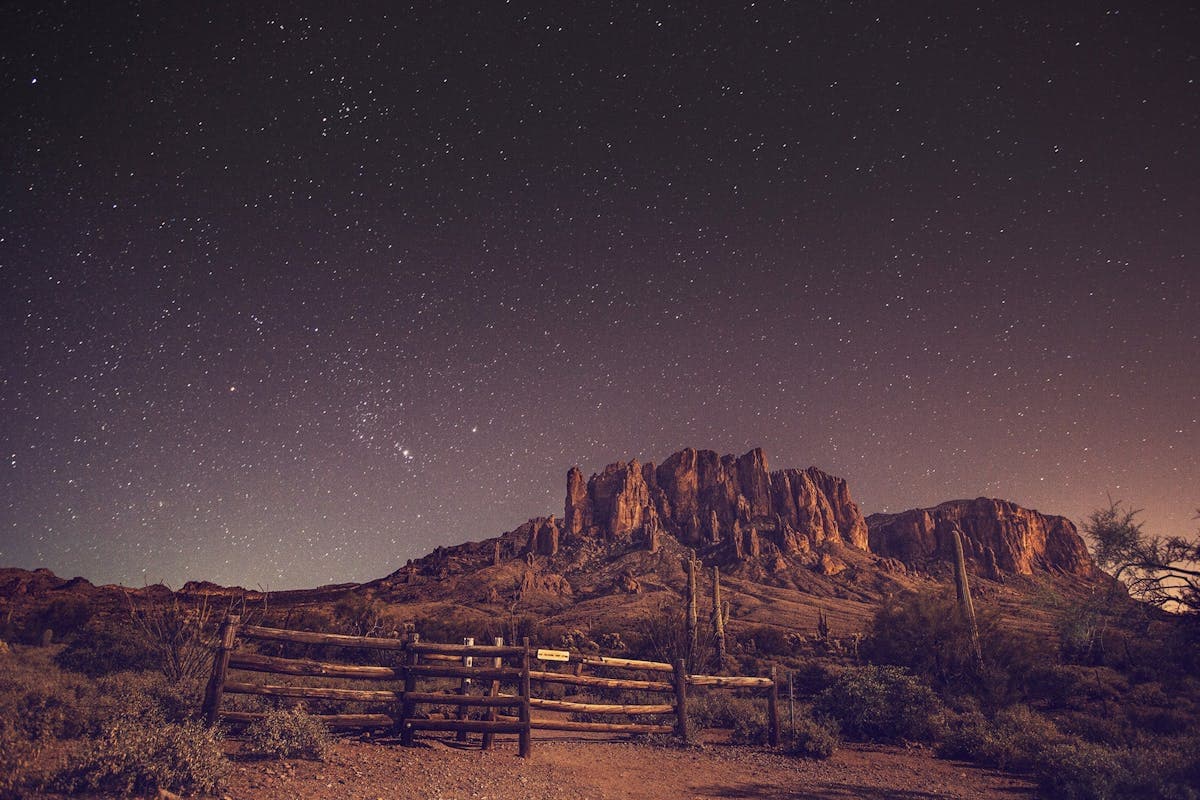 Breathtaking starry night sky above desert mountains, representing the remote and mysterious landscape of Utah's Uinta Basin