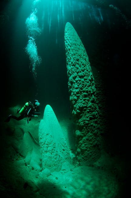 Scuba diver explores natural rock formations underwater in a serene diving adventure